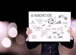 Personne tenant un panneau "Innovation"